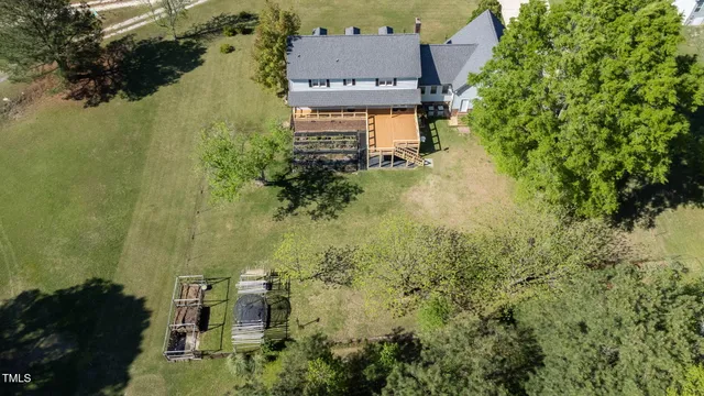 an aerial view of residential house with outdoor space and trees all around