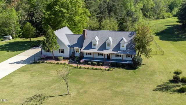 a view of a house with pool and sitting area