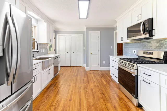 a kitchen with stainless steel appliances a stove sink and refrigerator