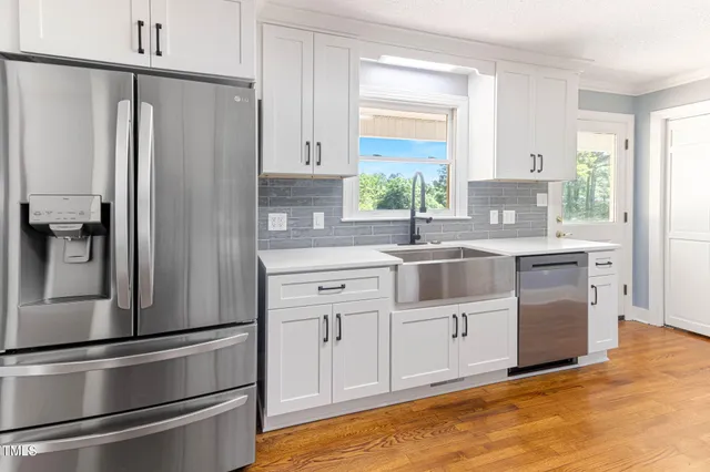a kitchen with white cabinets and stainless steel appliances