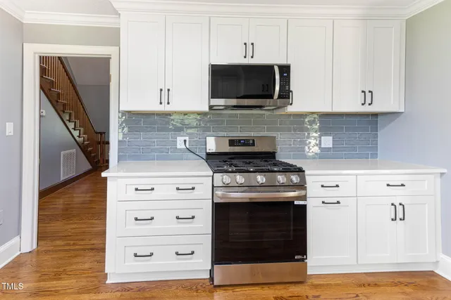 a kitchen with stainless steel appliances granite countertop a stove and a microwave