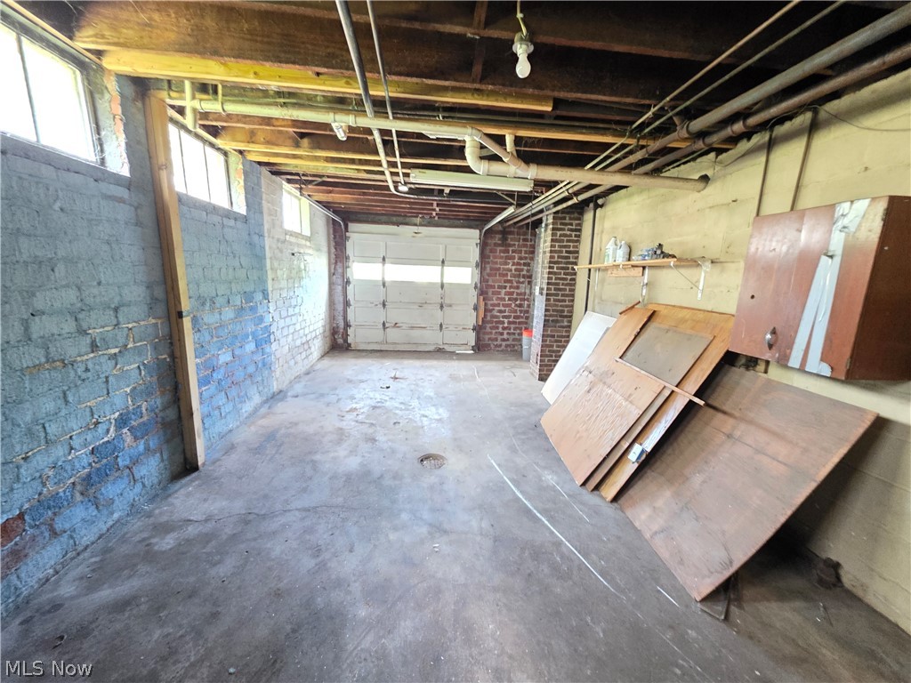 1801 West Prospect Road Ashtabula, OH 44004 - Photo 26 of 35 Garage located beneath home, exposed wood ceiling beams, concrete flooring, and an overhead garage door