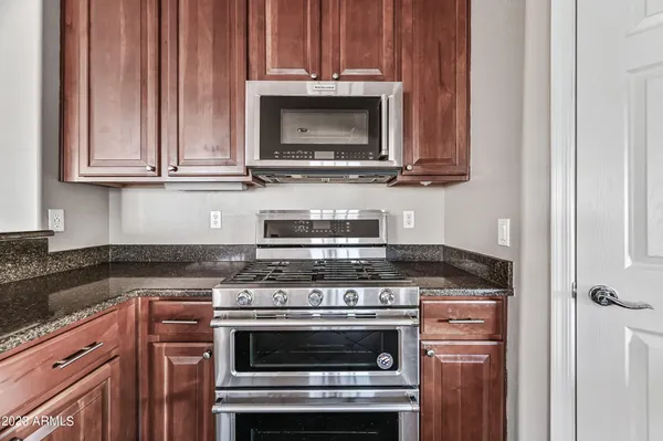 a kitchen with granite countertop wood cabinets and stainless steel appliances