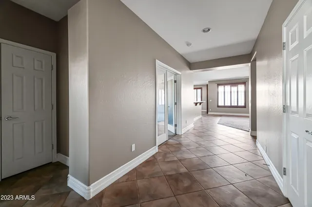 a view of a hallway with wooden floor and a living room