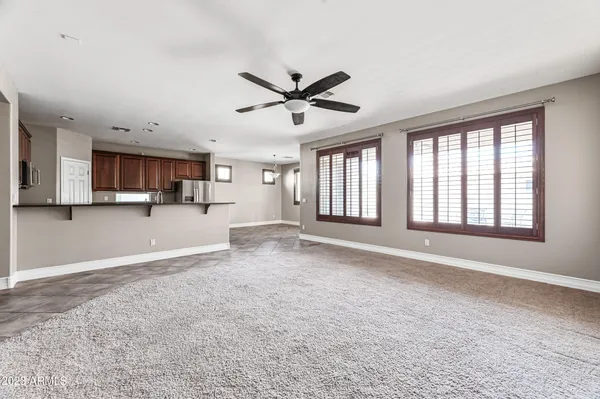 an empty room with windows and ceiling fan