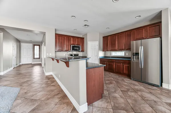 a kitchen with stainless steel appliances granite countertop a stove top oven a refrigerator a sink and dishwasher