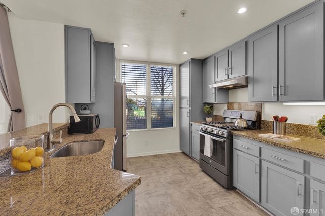 a kitchen with stainless steel appliances granite countertop a sink stove and refrigerator