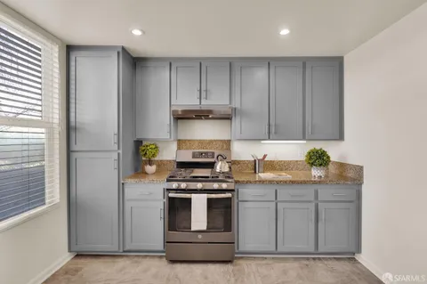 a kitchen with stainless steel appliances granite countertop a stove and a refrigerator with cabinets