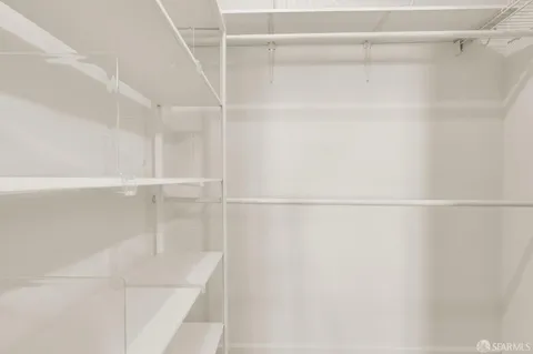 a view of walk in closet with empty racks