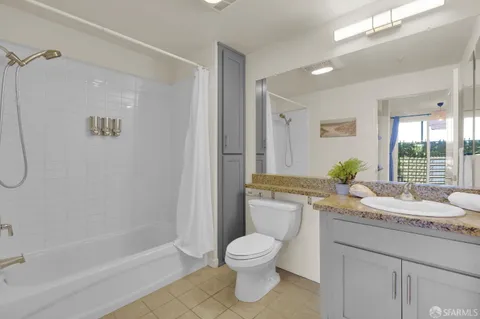 a bathroom with a granite countertop toilet a sink and a bathtub