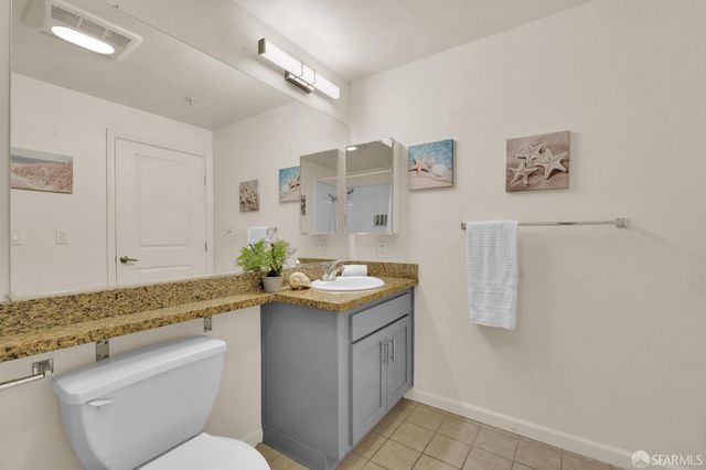 a spacious bathroom with a granite countertop sink and a mirror