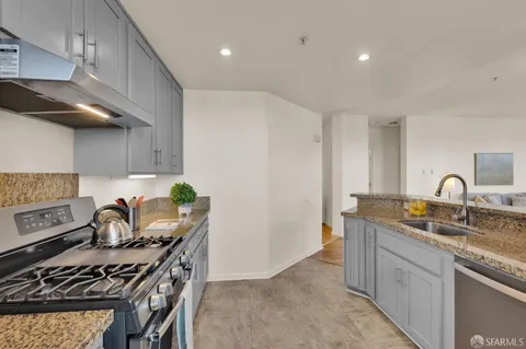 a kitchen with stainless steel appliances granite countertop a sink stove and cabinets