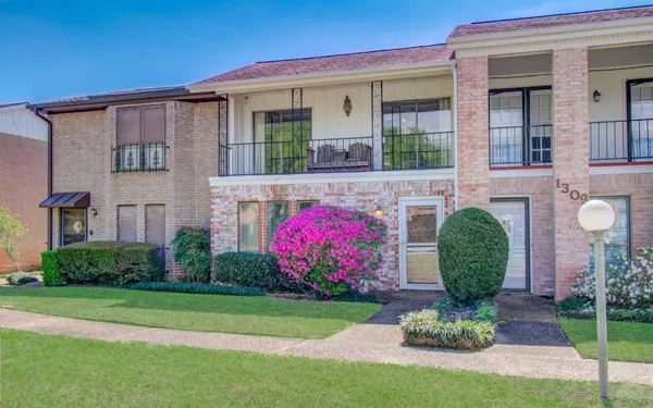 a front view of a house with a yard and plants