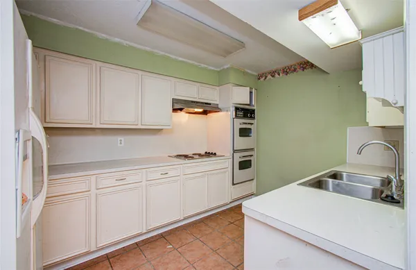 a kitchen with stainless steel appliances a sink stove and cabinets