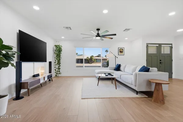 a kitchen with stainless steel appliances a refrigerator a stove top oven a sink dishwasher and a dining table with wooden floor