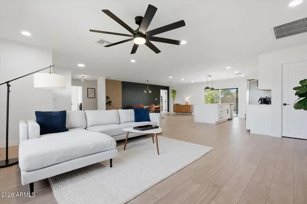 a living room with furniture a flat screen tv and a potted plant