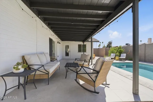 a view of swimming pool with lawn chairs and plants