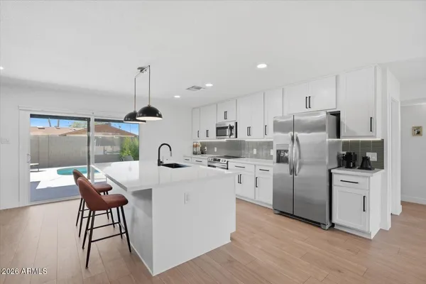 a kitchen with sink and white cabinets