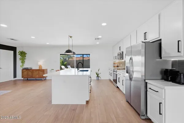 a kitchen with white cabinets and stainless steel appliances