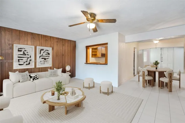 a living room with furniture and a dining table with wooden floor