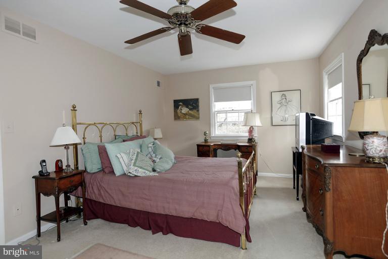 7613 Sebago Road Bethesda, MD 20817 - Photo 15 of 26 a bedroom with a bed and a chandelier