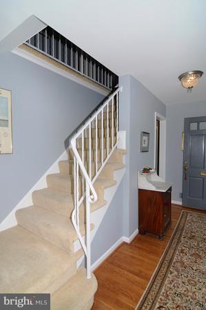 7613 Sebago Road Bethesda, MD 20817 - Photo 21 of 26 a view of staircase and living room with wooden floor