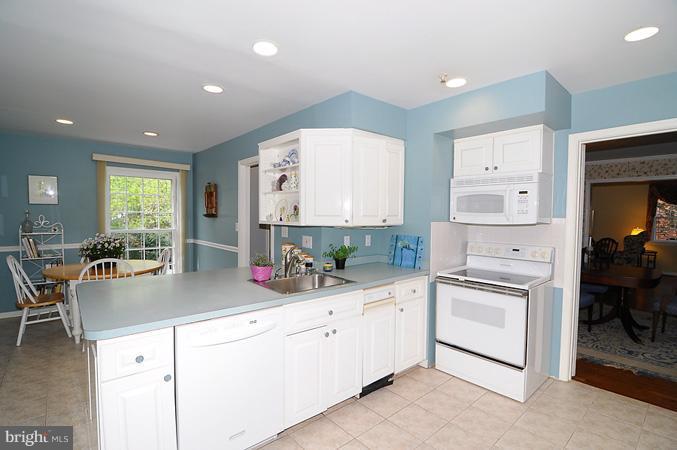 7613 Sebago Road Bethesda, MD 20817 - Photo 7 of 26 a kitchen with white cabinets and white appliances