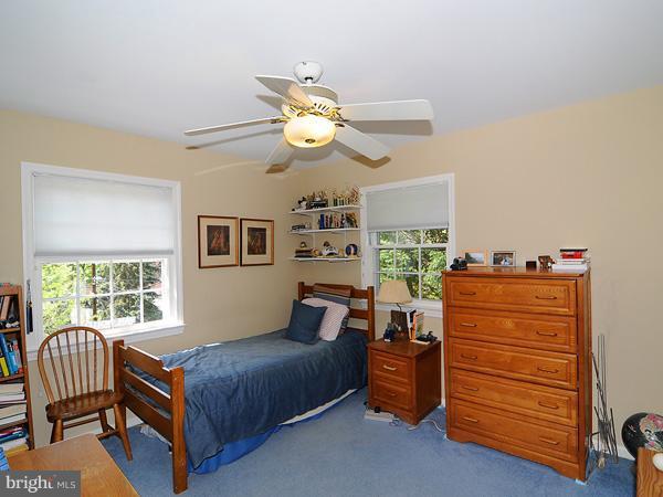 7613 Sebago Road Bethesda, MD 20817 - Photo 10 of 26 a bedroom with a bed and a chandelier
