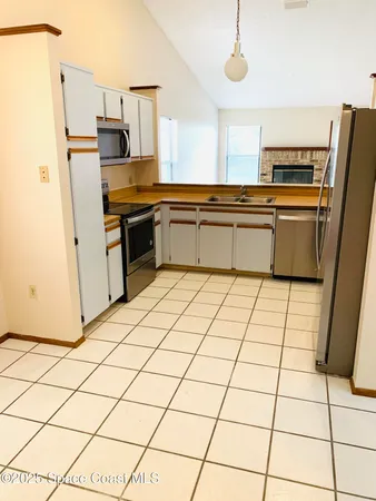 a kitchen with granite countertop a refrigerator and a stove top oven