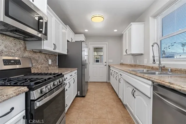 a large kitchen with stainless steel appliances granite countertop a lot of counter space and a sink