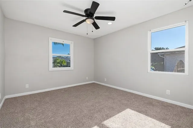 an empty room with a window and a ceiling fan