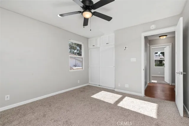 an empty room with closet and windows