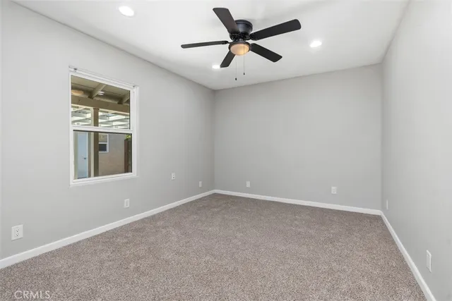 an empty room with a window and a ceiling fan