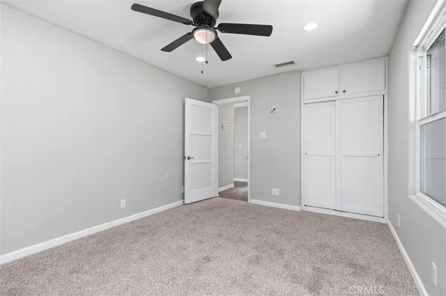 an empty room with chandelier fan