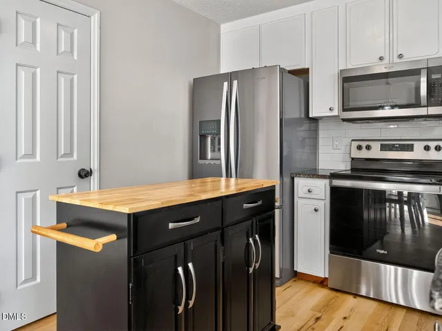 a kitchen with stainless steel appliances a stove microwave and refrigerator