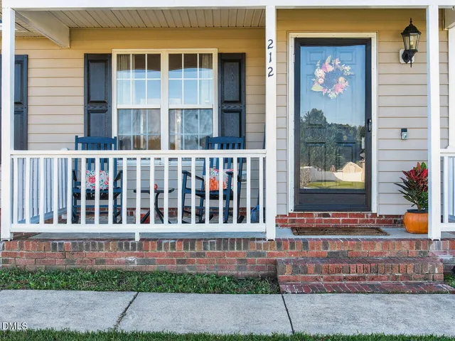 a view of a brick building with a bench in front of house