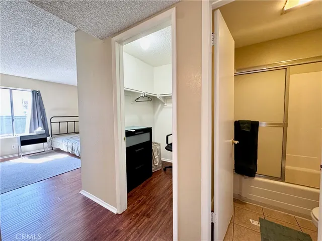 a view of a living room with a hallway and wooden floor