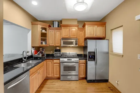 a kitchen with stainless steel appliances granite countertop a stove a sink and a refrigerator