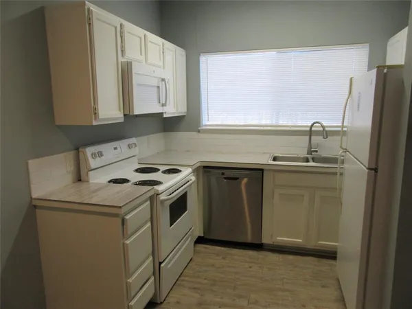 a kitchen with a sink stove and refrigerator