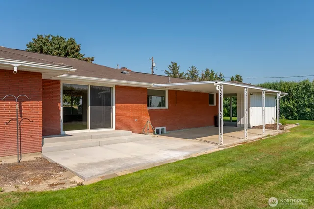 a front view of a house with a yard and potted plants