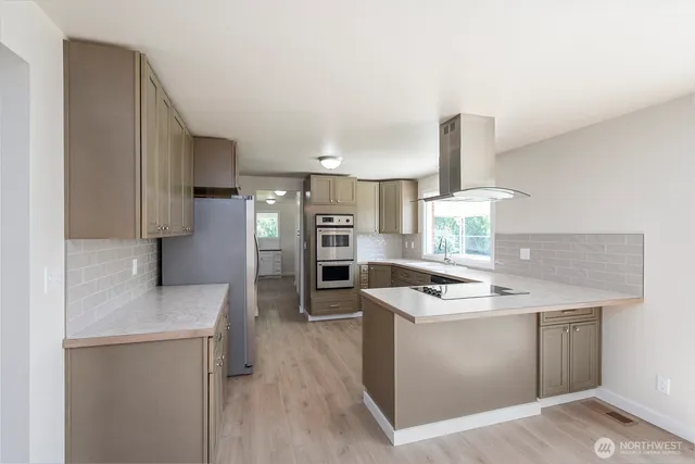 a kitchen with stainless steel appliances granite countertop a sink stove and refrigerator