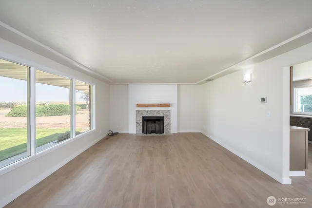a view of an empty room with a window and fireplace