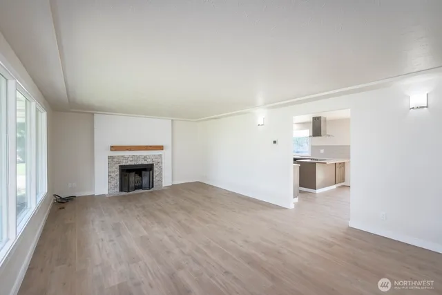 a view of empty room with wooden floor and fireplace