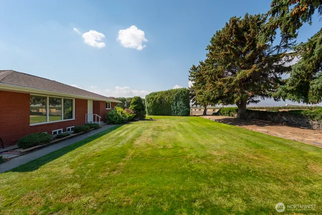 a view of a house with swimming pool and a yard
