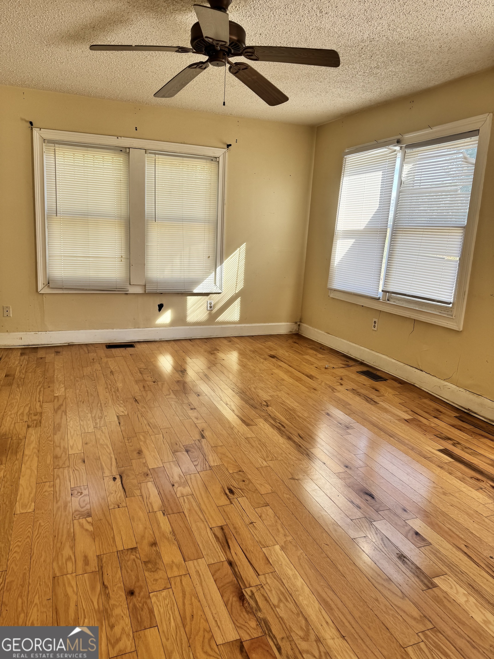 1179 Panola Road Stone Mountain, GA 30088 - Photo 8 of 15 an empty room with wooden floor fan and windows
