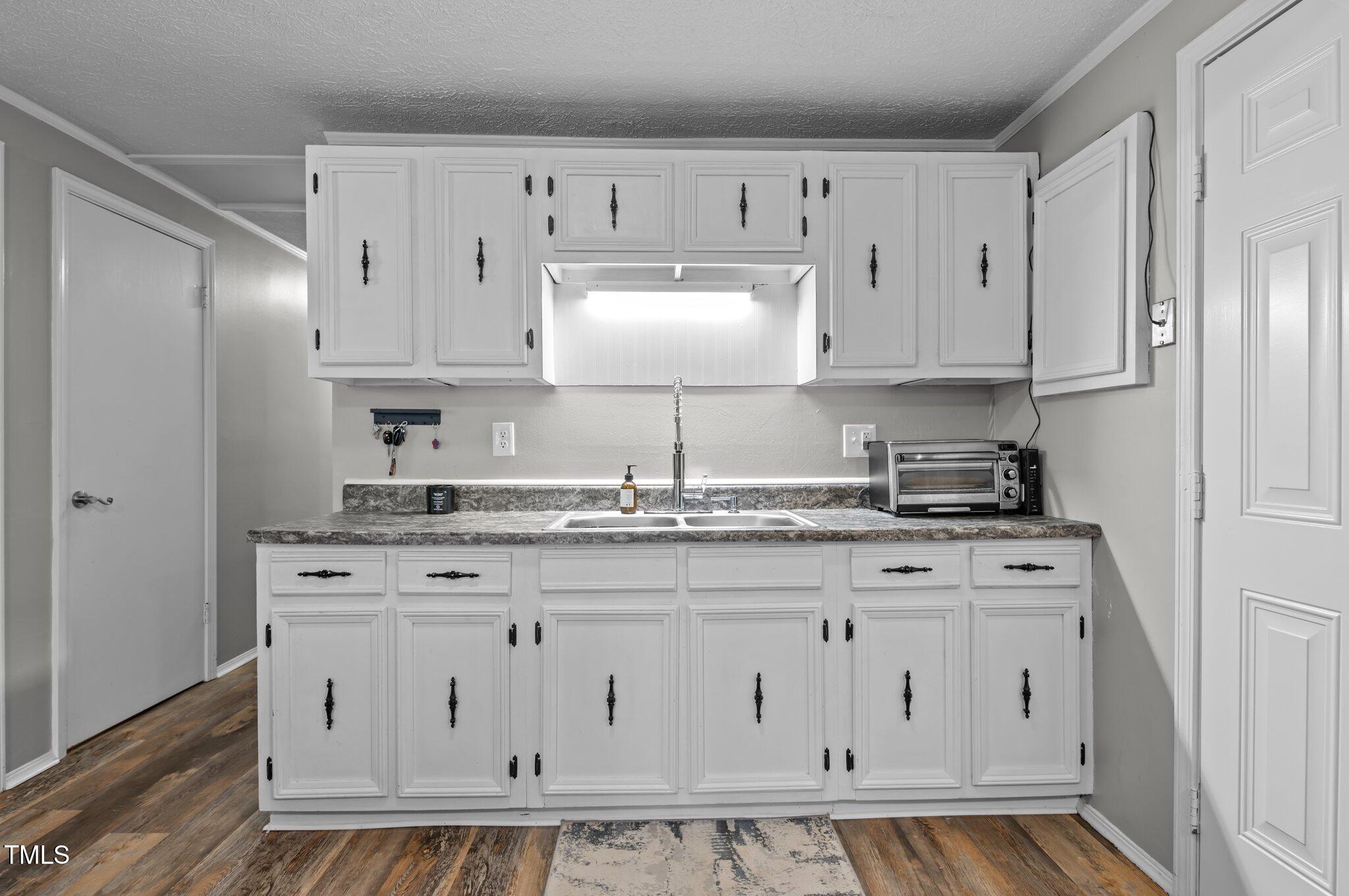 749 Fred Royster Road Henderson, NC 27537 - Photo 10 of 31 a kitchen with granite countertop white cabinets and stainless steel appliances