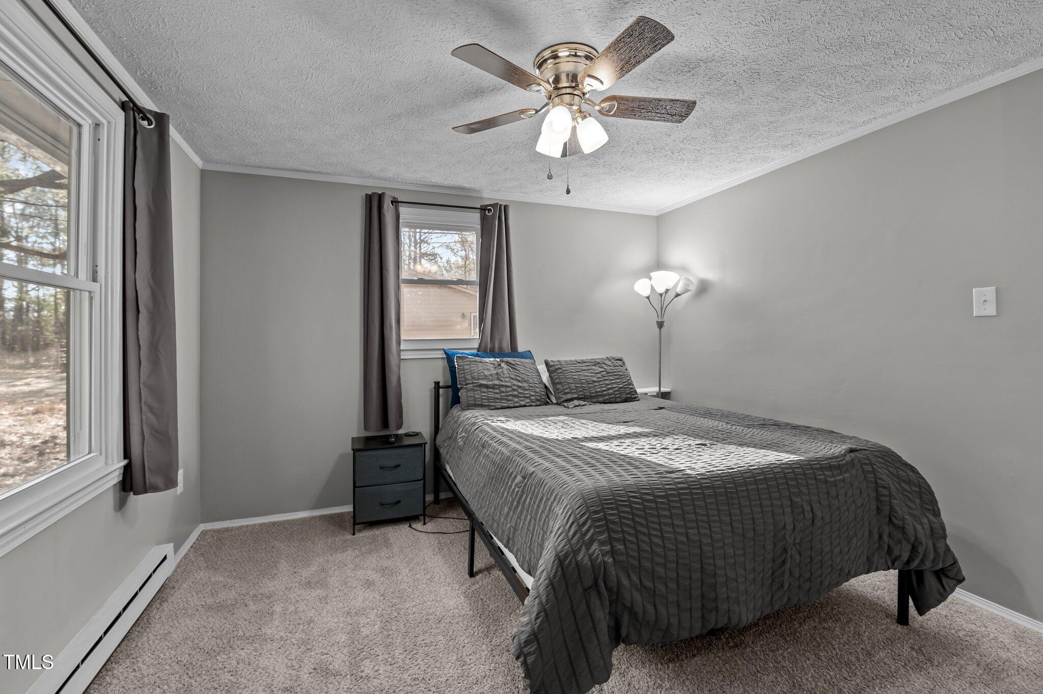 749 Fred Royster Road Henderson, NC 27537 - Photo 16 of 31 a spacious bedroom with a bed and a chandelier