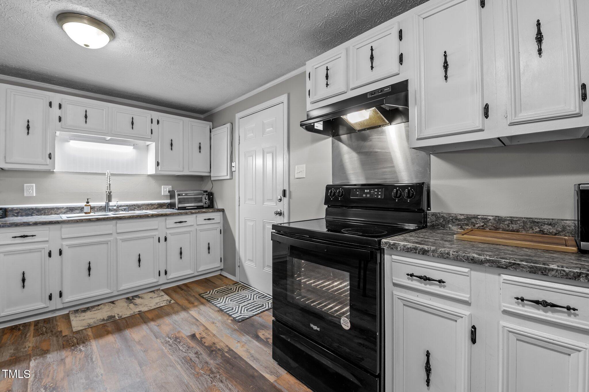 749 Fred Royster Road Henderson, NC 27537 - Photo 9 of 31 a kitchen with granite countertop white cabinets and appliances