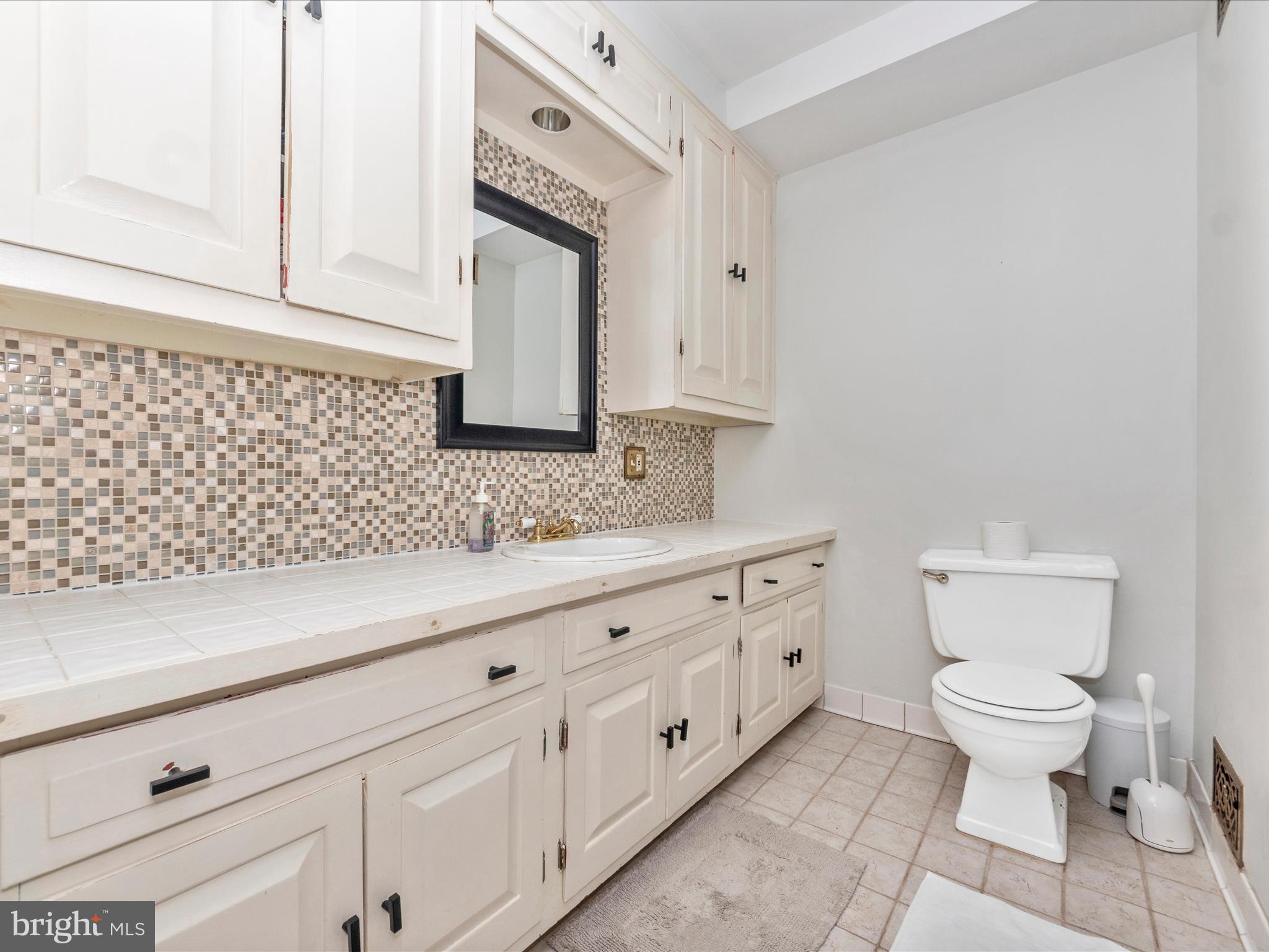 23 East Wheeling Street Baltimore, MD 21230 - Photo 35 of 51 a bathroom with a granite countertop toilet sink and mirror