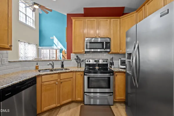 a kitchen with stainless steel appliances granite countertop a sink stove and refrigerator